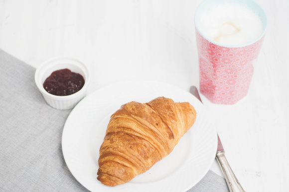 Frühstück mit Croissant und Milchkaffee